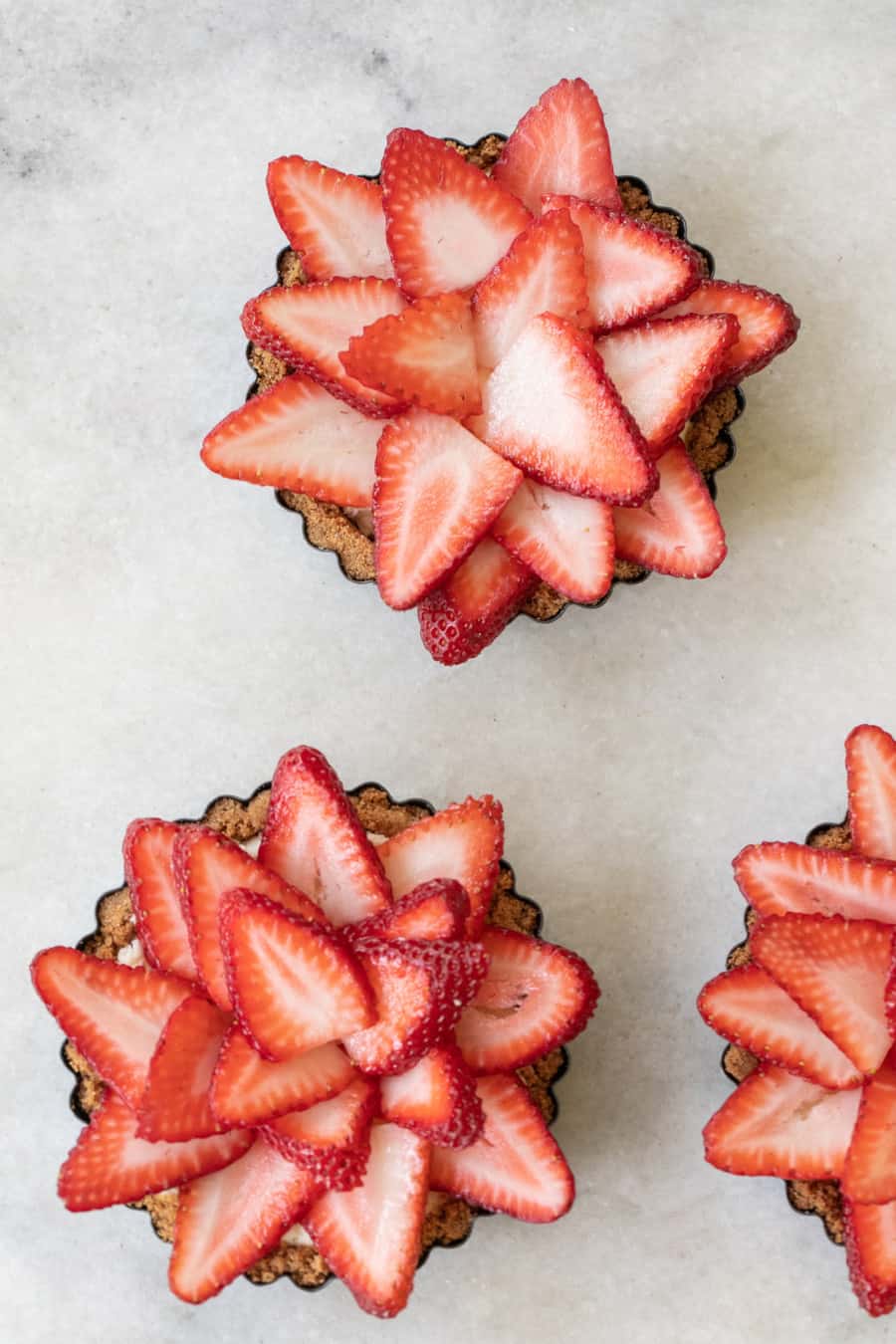 Mini pies with sliced strawberries for the 4th of July.