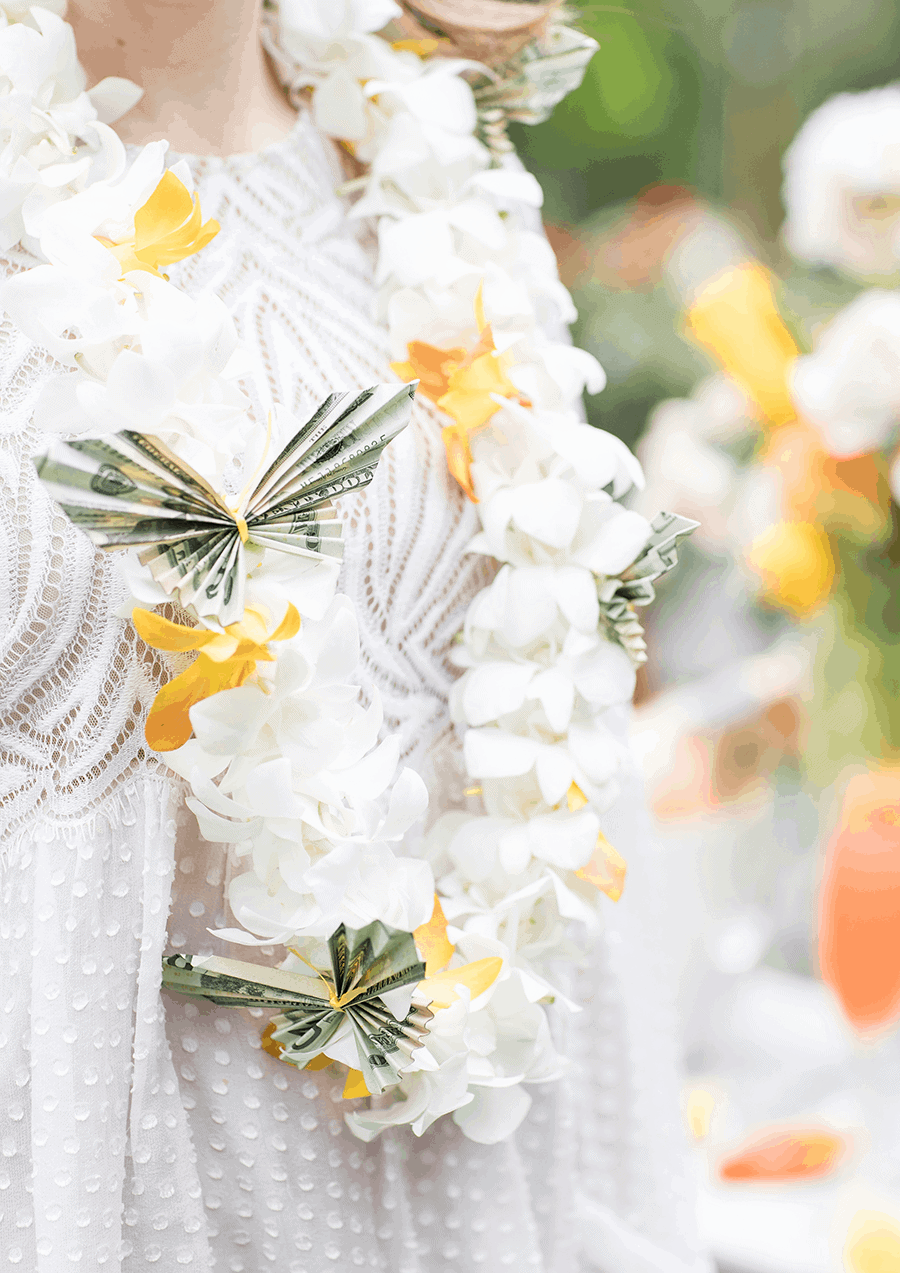 Butterfly Money Lei on a girl with a white dress. - graduation party ideas