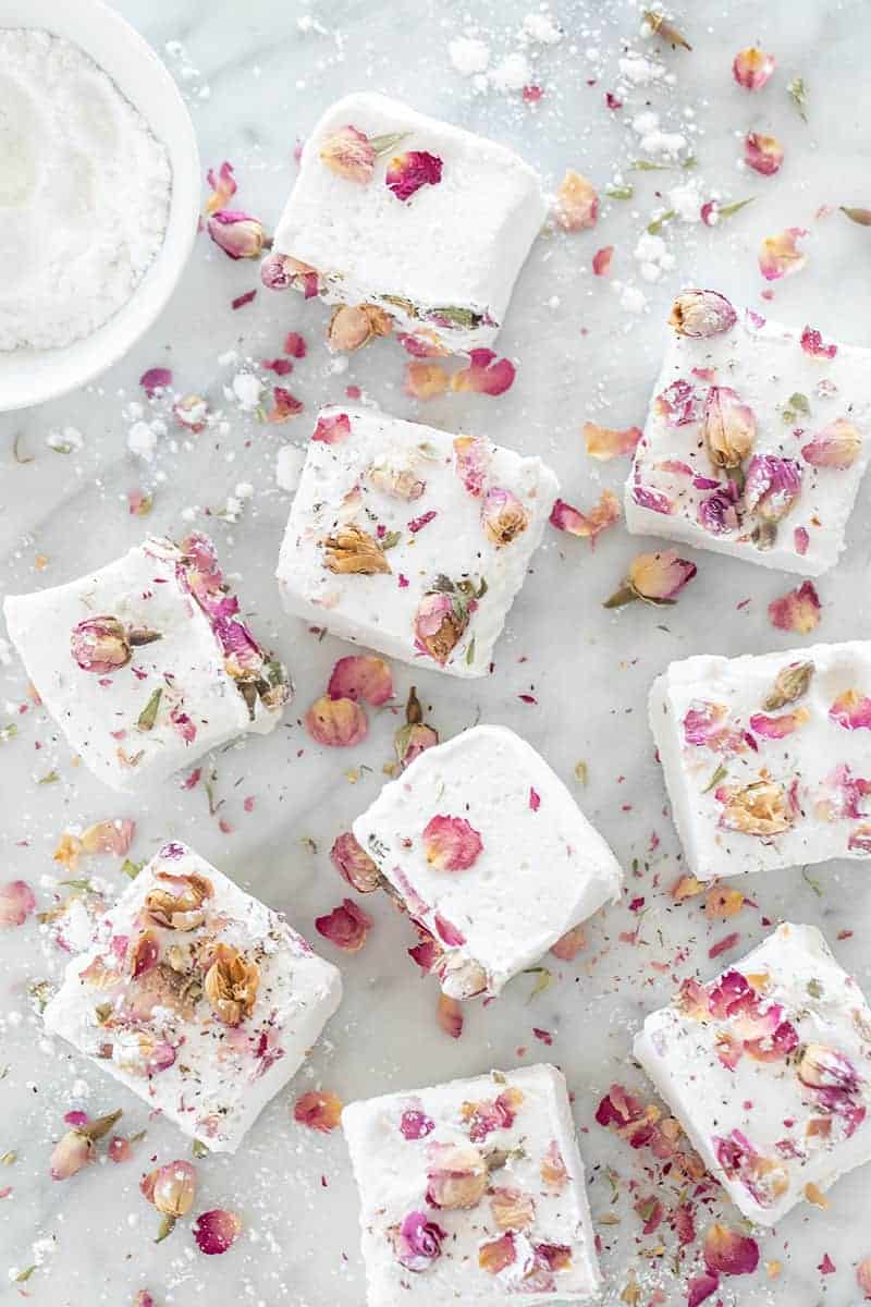 Giant, white fluffy homemade marshmallows with dried edible rose petals over them. 