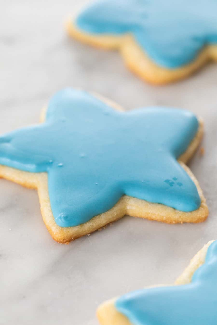 Star shaped sugar cookies with blue royal icing.