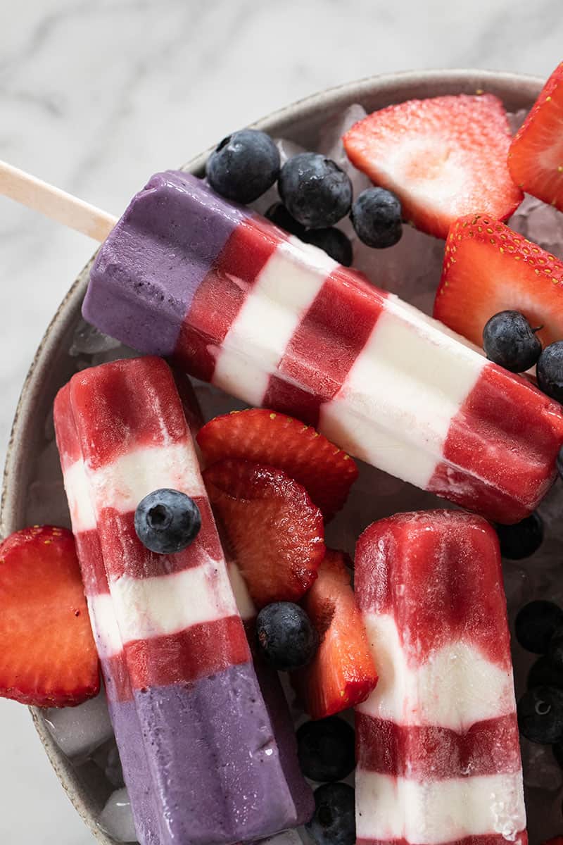 Striped bomb pops with blueberries and strawberries.