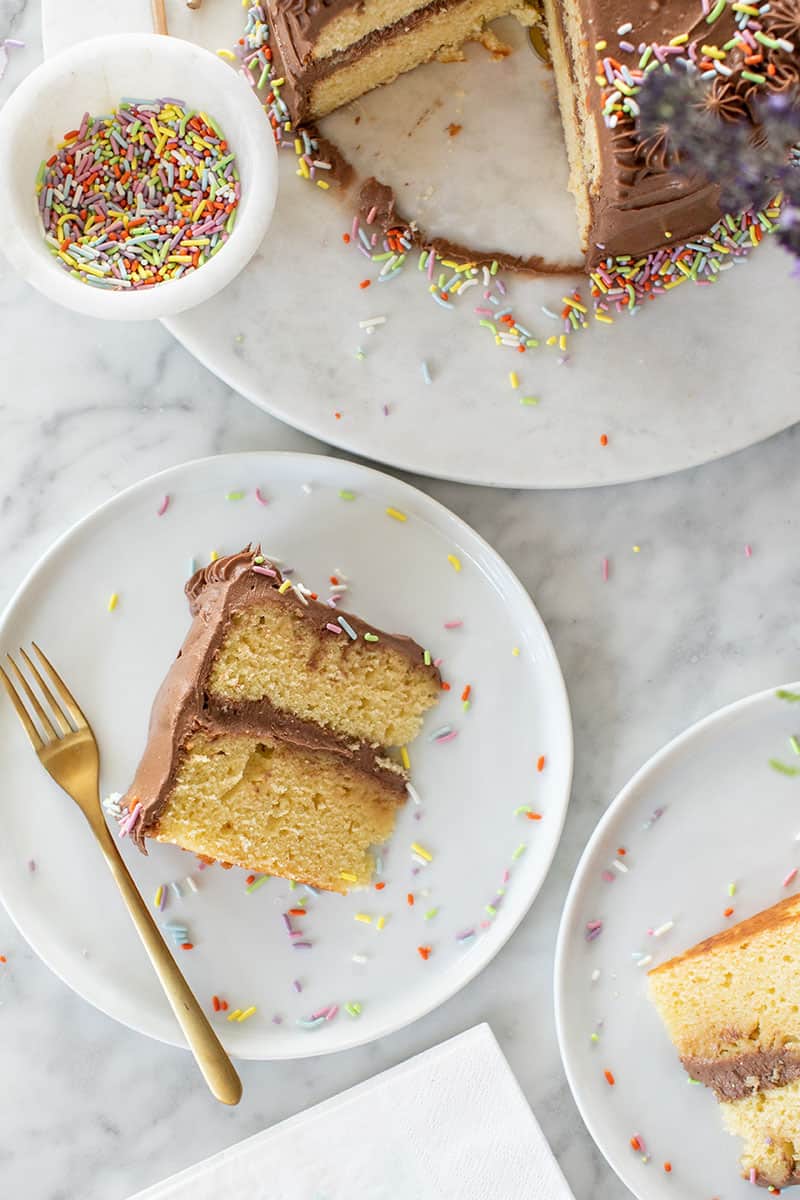 Slice of yellow birthday cake with chocolate icing. 