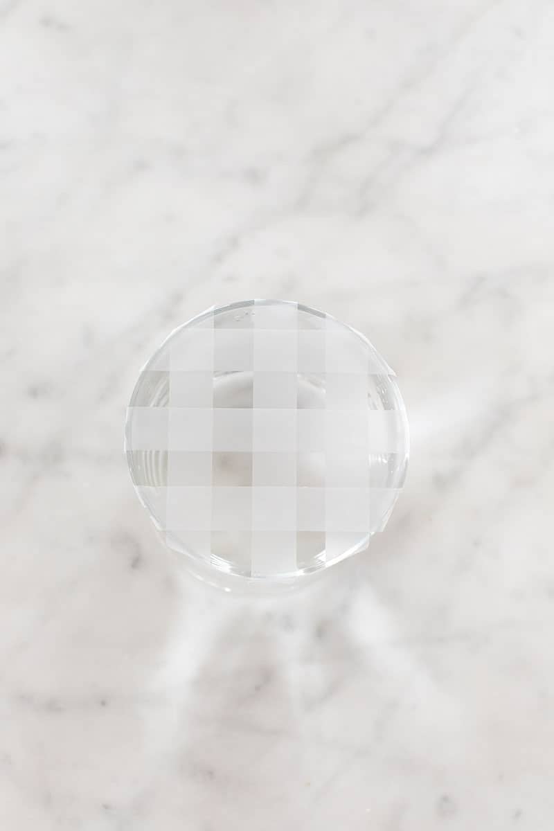 A grid taped to an old candle jar to use as a flower arrangement.