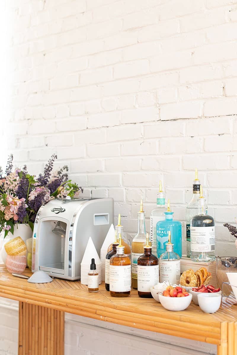 Snow cone bar with a snow cone machine and spirit bottles.