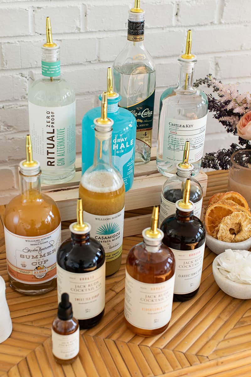 Spirit bottles and cocktail mixers with gold spouts.