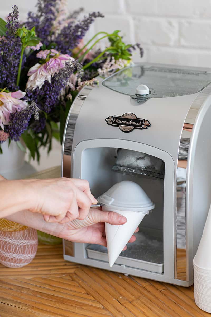 Using a tool to mold a snow cone. 