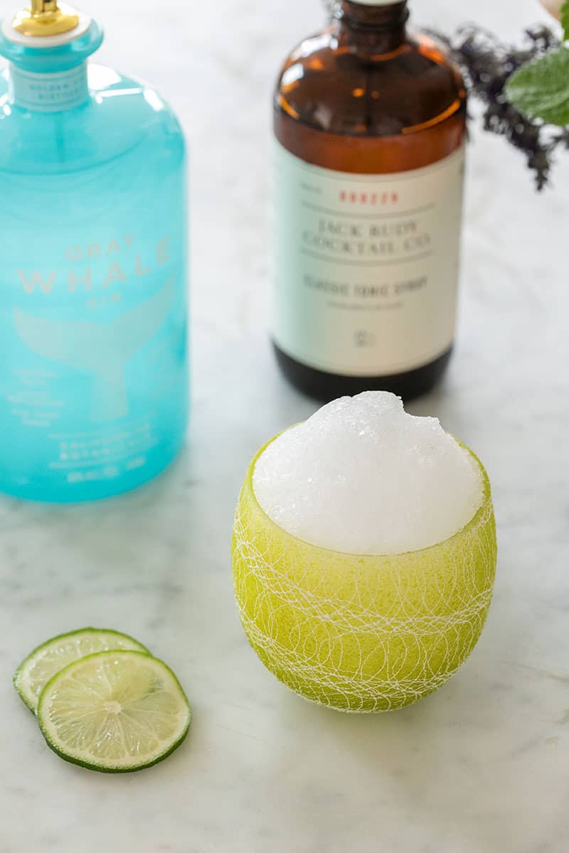 Gin and tonic snow cone in a green cup.