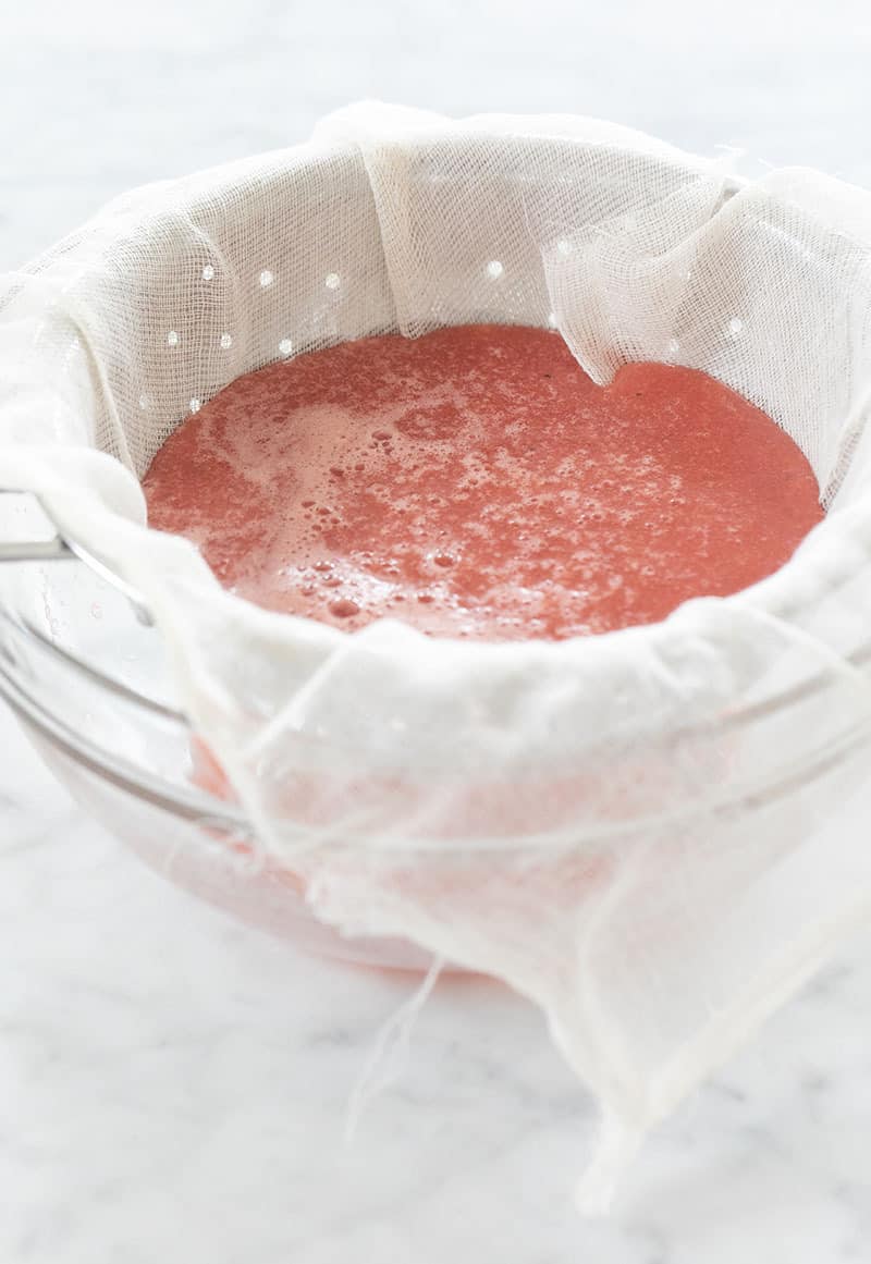 watermelon cucumber cooler straining in a cheesecloth 