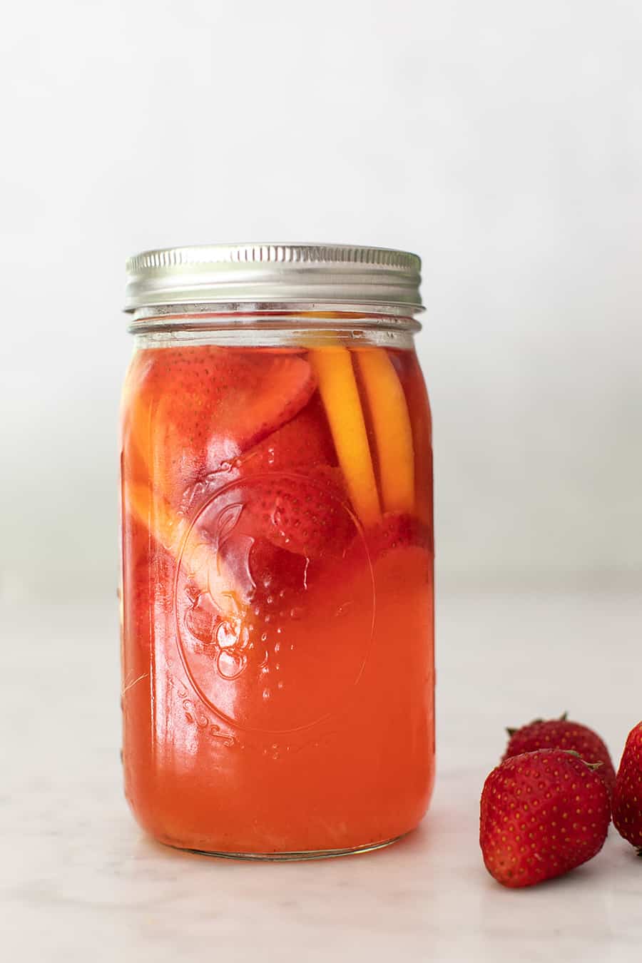 Strawberry lemonade in a jar with strawberries. 