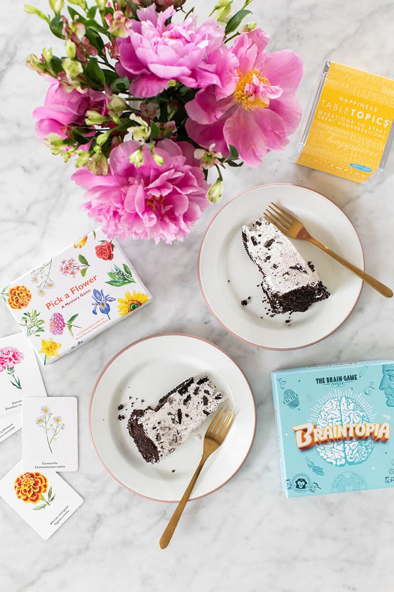 Family game night with a slice of Oreo cake and games on a marble table.