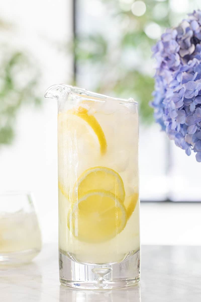 Homemade lemonade in a pitcher with sliced lemons. 