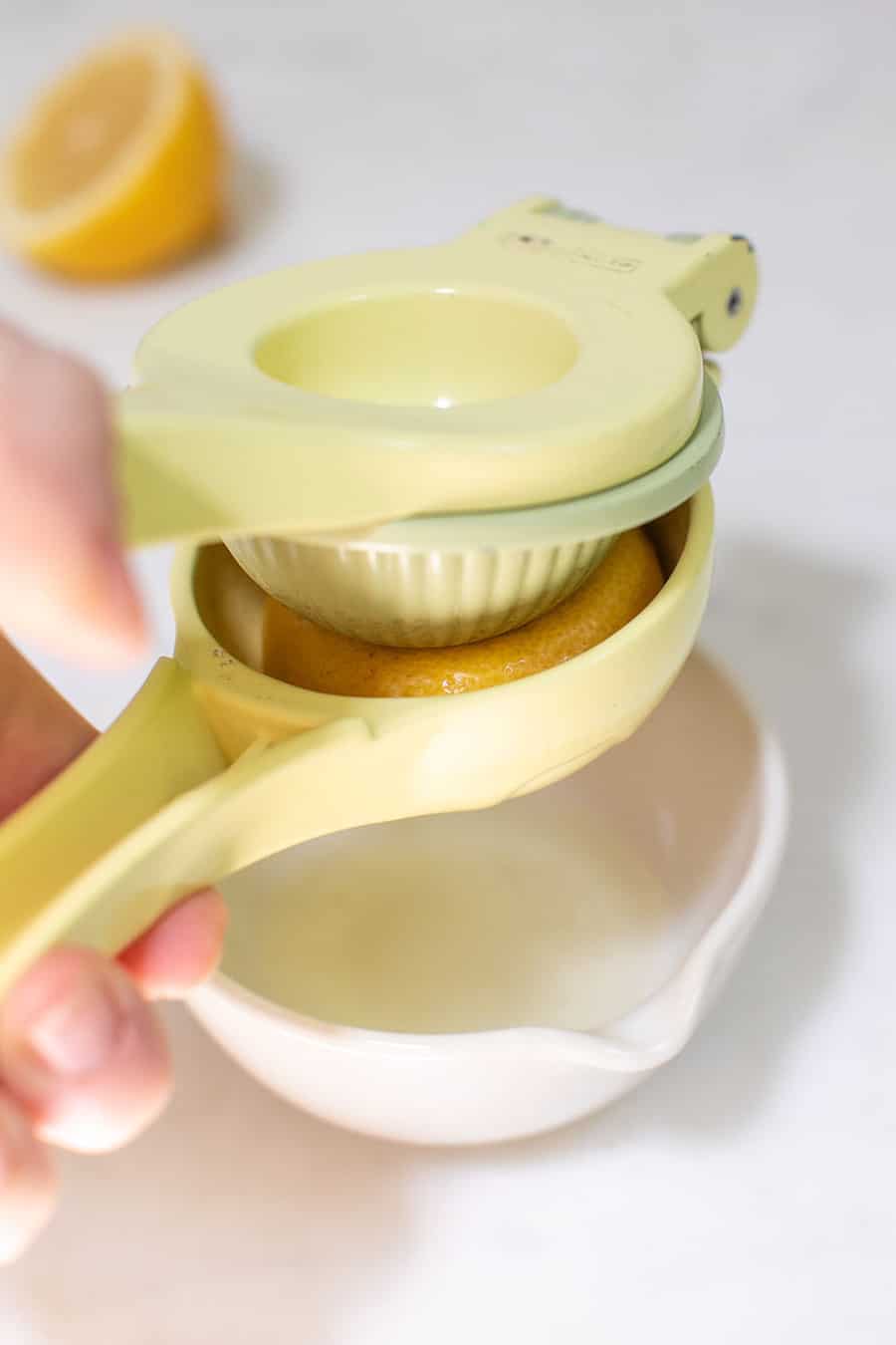 Pressing fresh lemon juice into a bowl. 