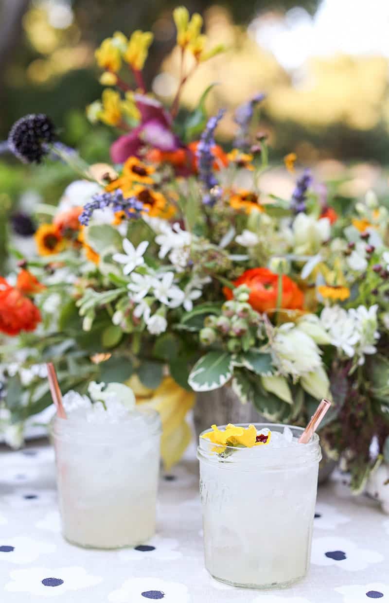 Limonada con flores en una mesa de exterior para cenar al aire libre.