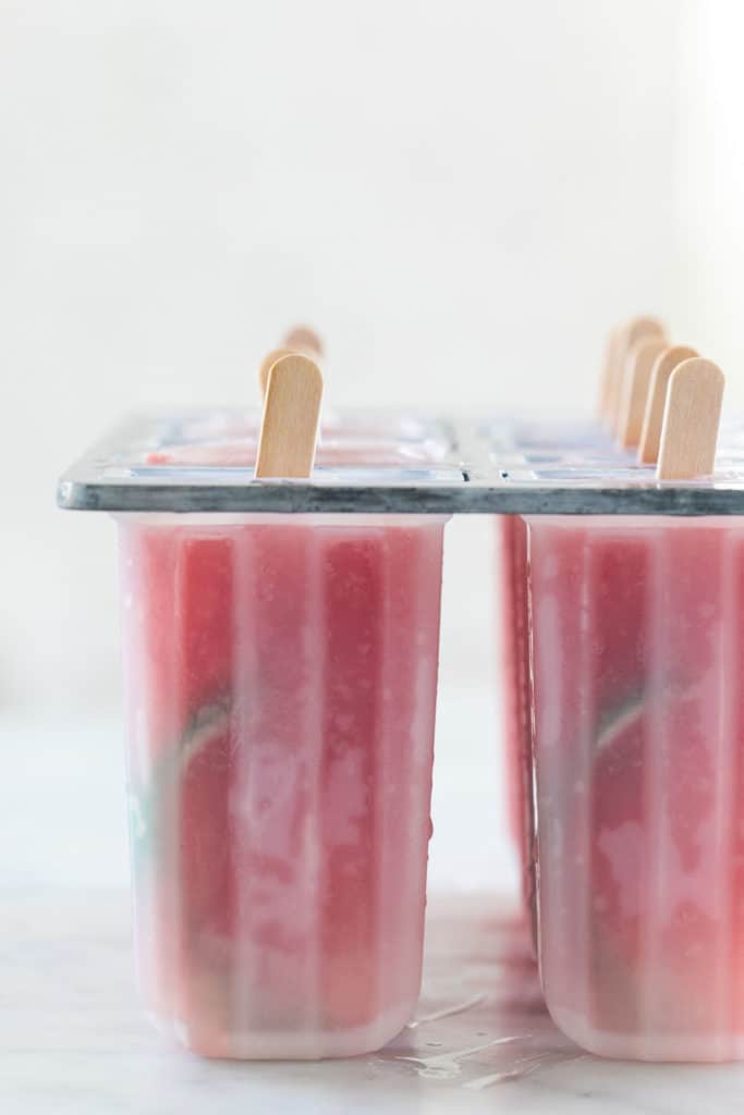 Frozen watermelon popsicles in a popsicle mold. 