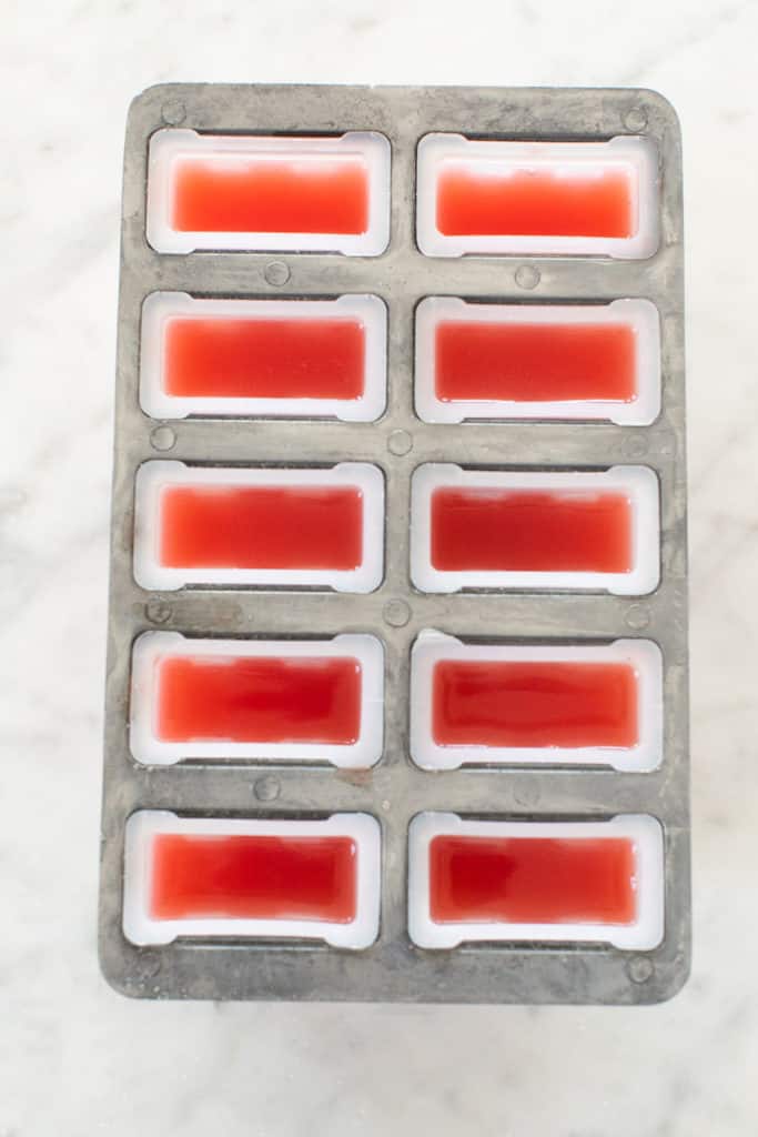 Watermelon juice poured into a popsicle mold. 