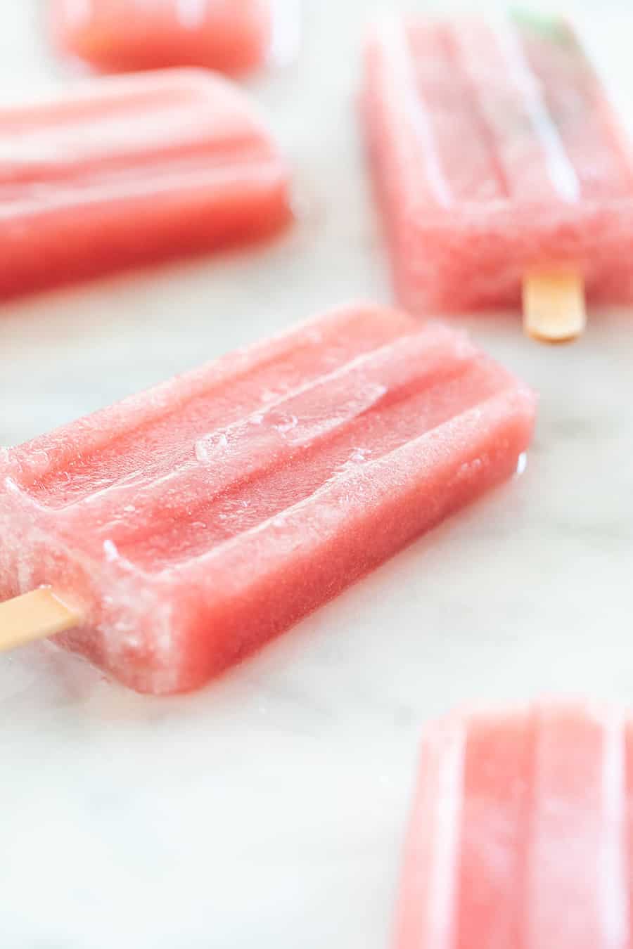 Fresh juice popsicles on a marble table. 