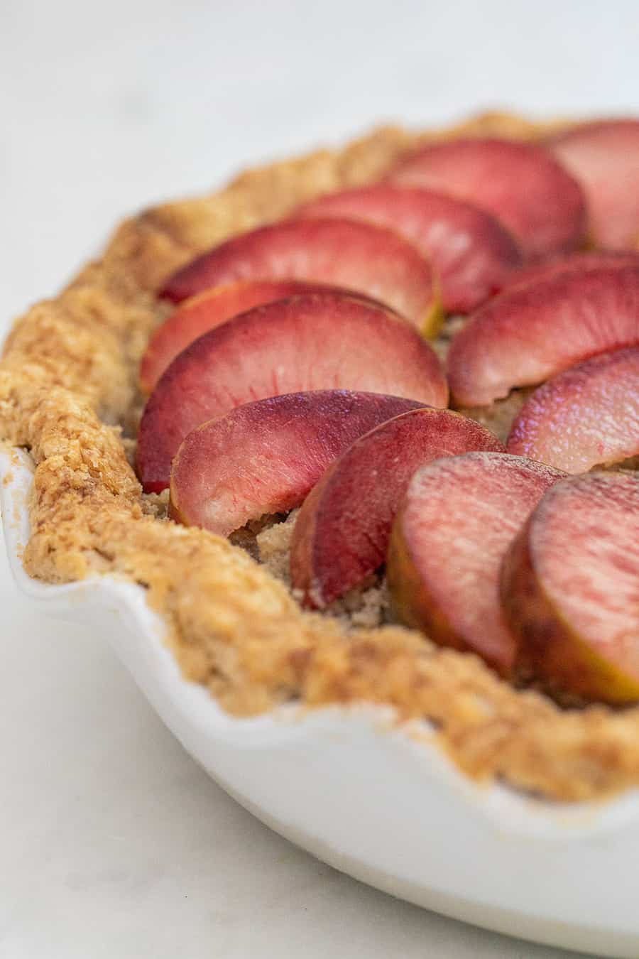 Aprium and plumcot pie with buttery pie crust and sliced plumcots.
