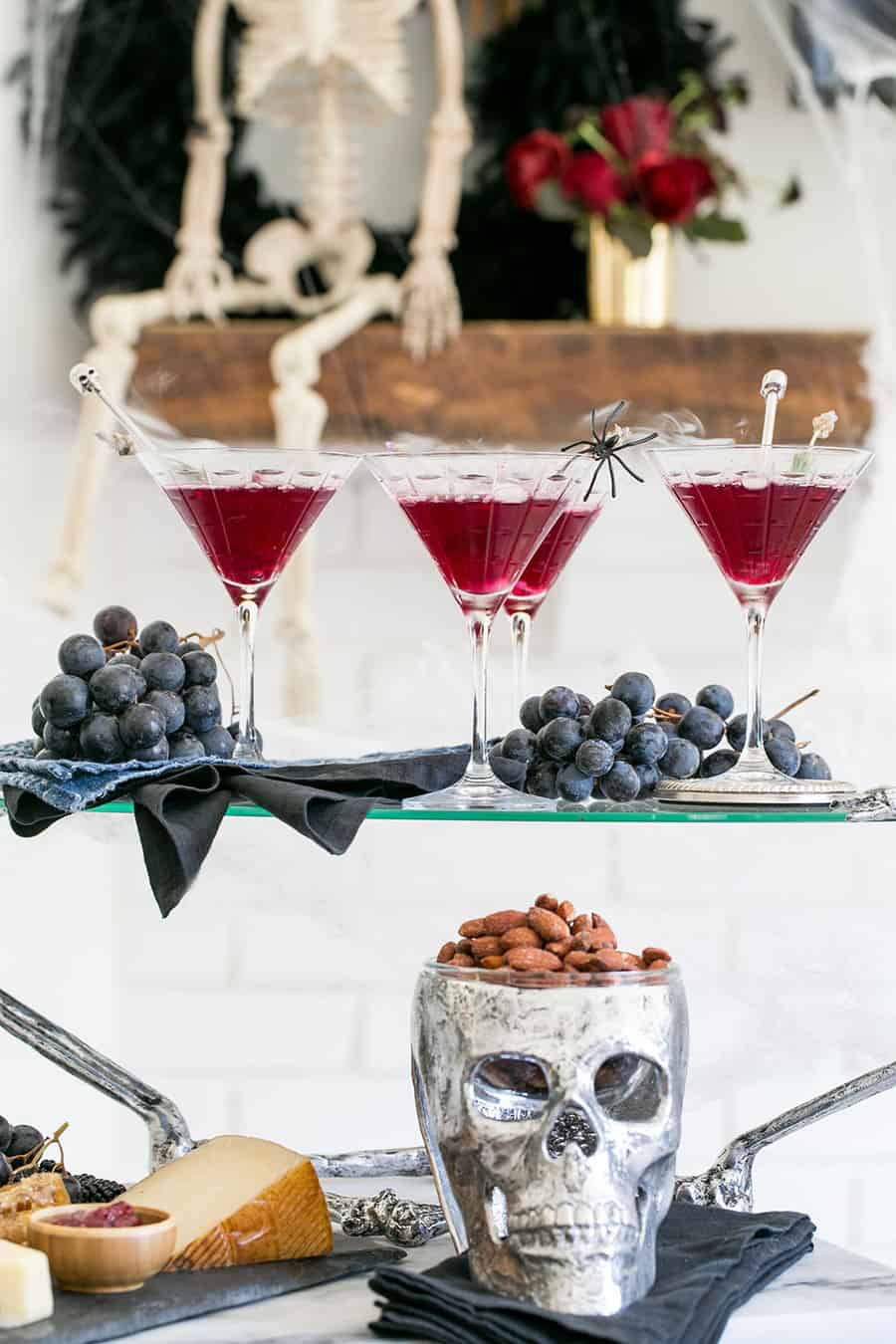 Halloween cocktails on a tray with a skeleton in the back.