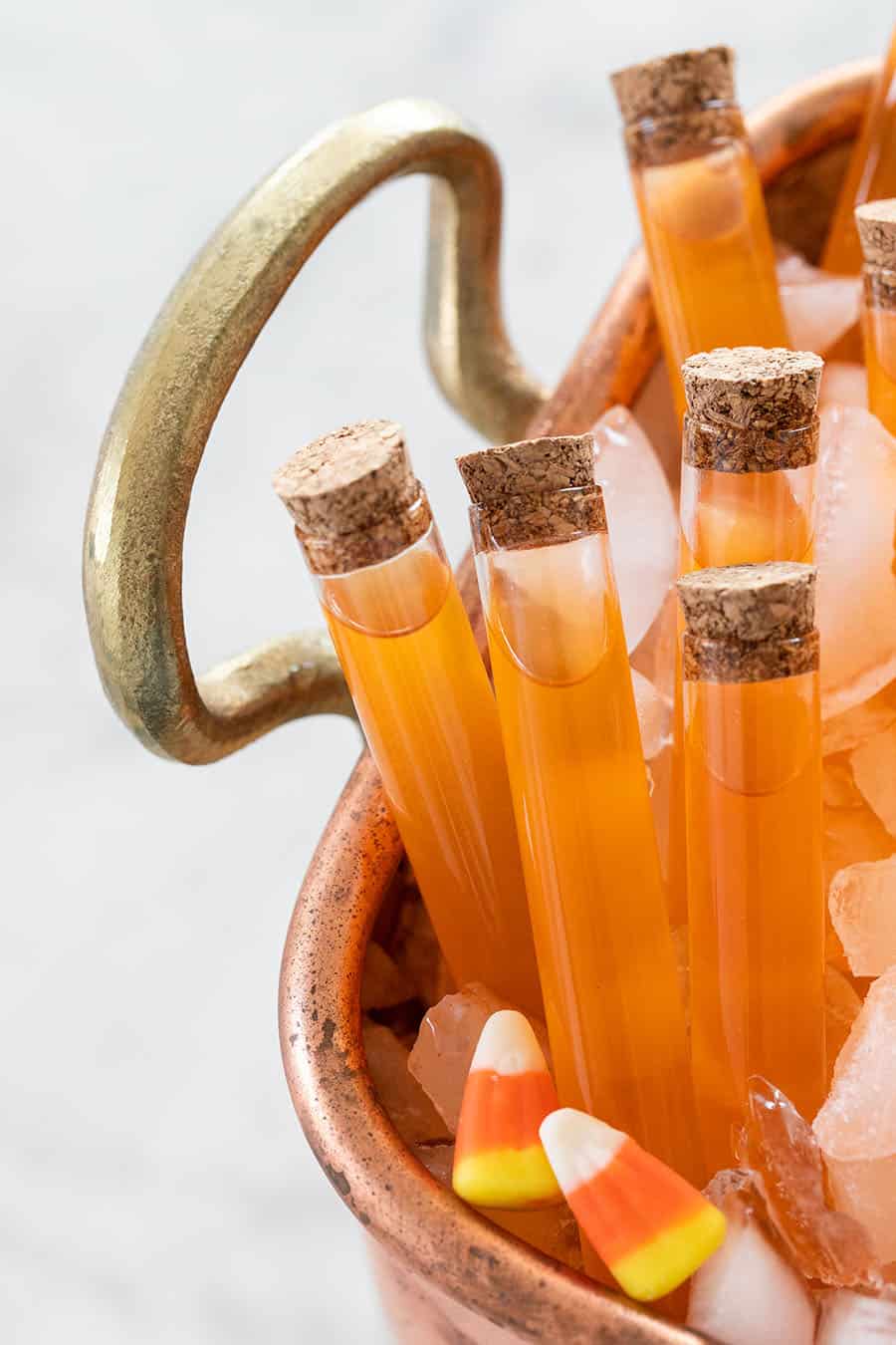 Orange drink inside test tubes with cork lids.