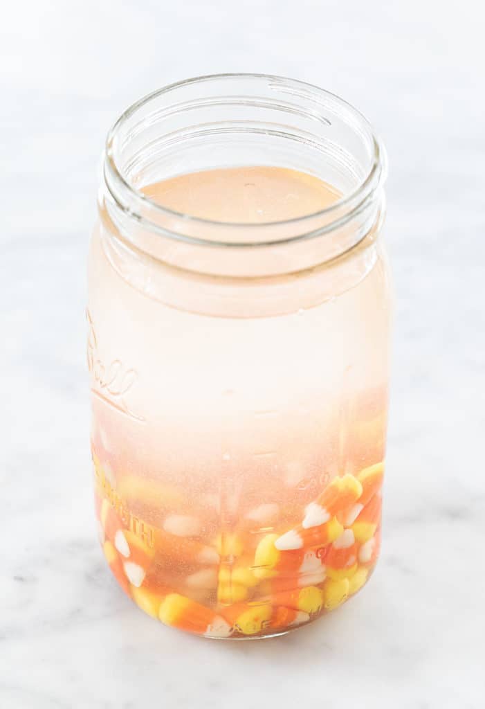Vodka and candy corns infusing to make candy corn shots. 