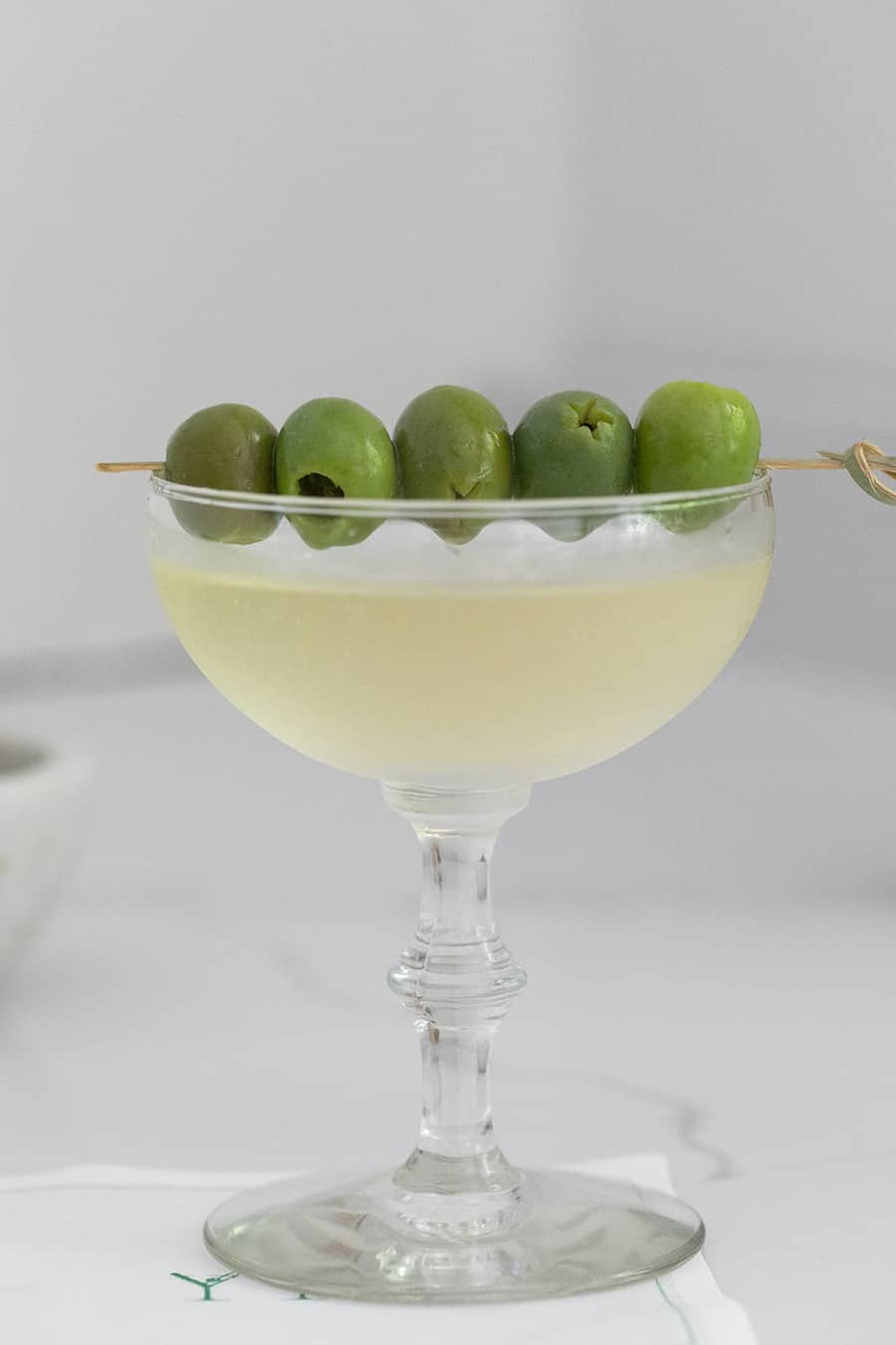 Green olives on a cocktail coupe