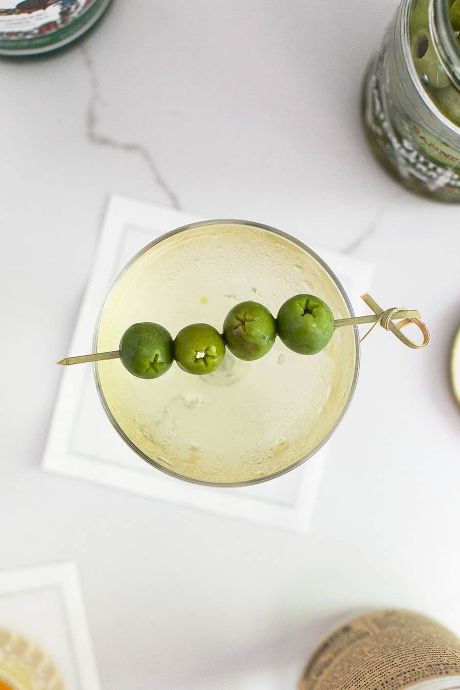 Dirty martini recipe in a coupe with 4 olives 