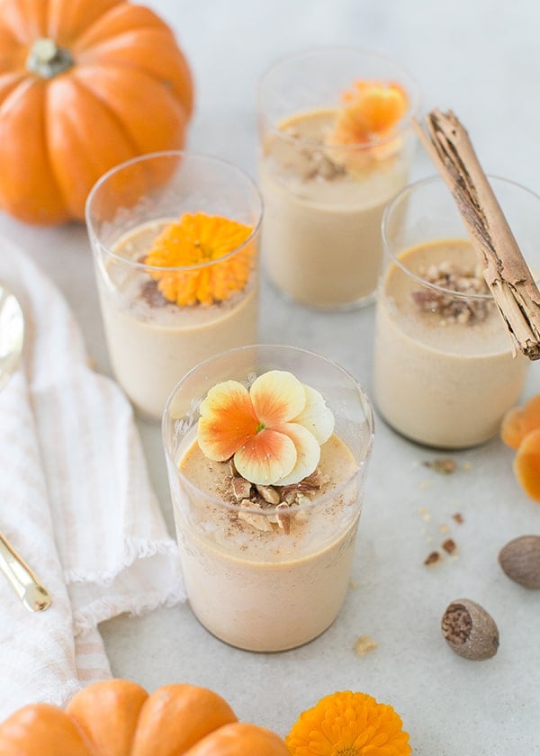 Pumpkin panna cotta halloween dessert with flowers and walnuts.