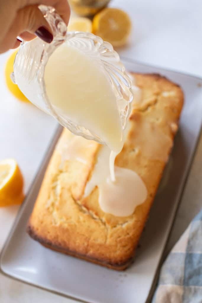 Pouring glaze over a moist lemon loaf.