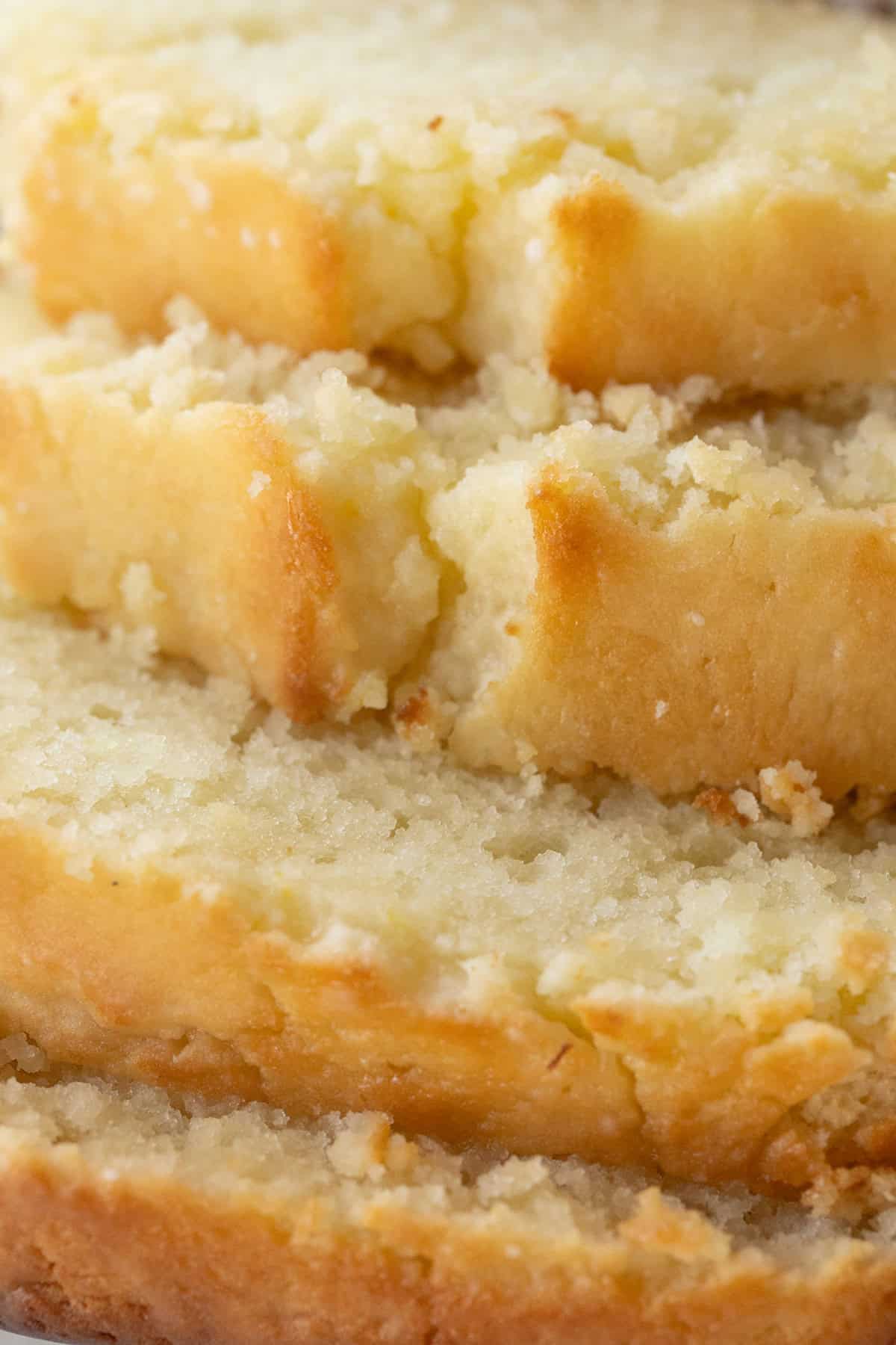 Close-up of freshly baked lemon loaf with powdered sugar glaze topping.