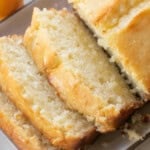 Super moist lemon loaf cake with buttery lemon flavor and texture sliced on a plate.