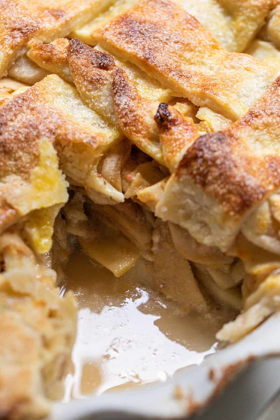 Close up of buttery apple pie crust with sliced apples