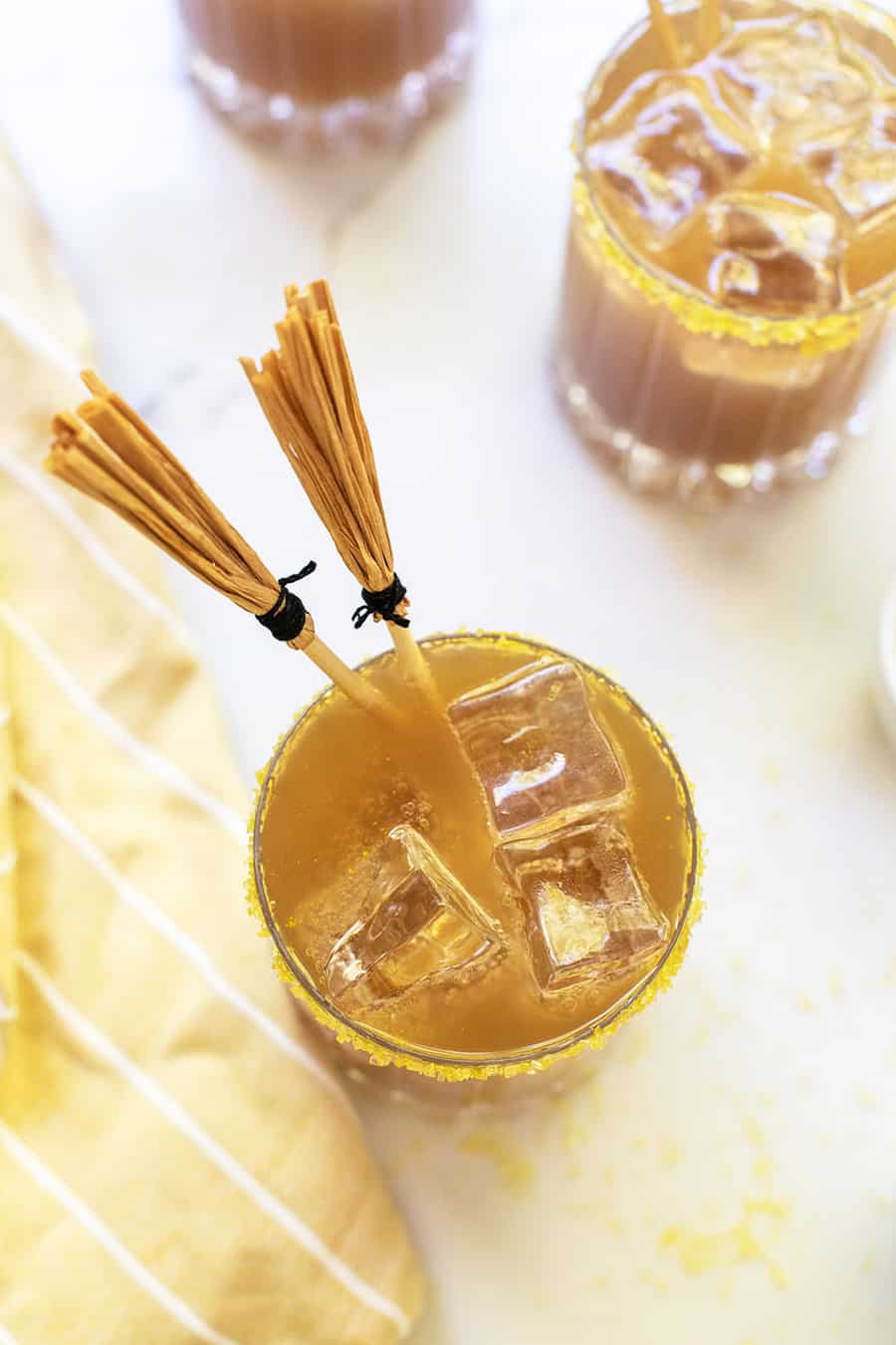 butterbeer recipe in a glass with ice and a yellow napkin.