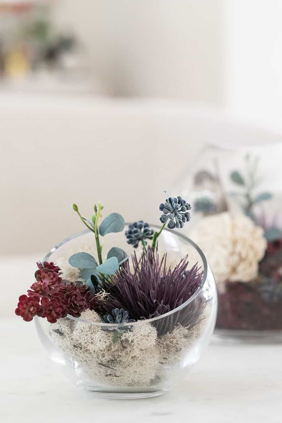 glass terrarium with flowers and moss