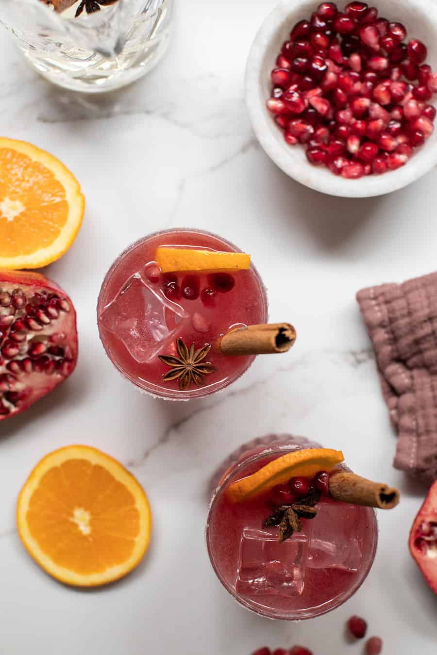 Pomegranate Margarita with orange slice and fresh pomegranates. 