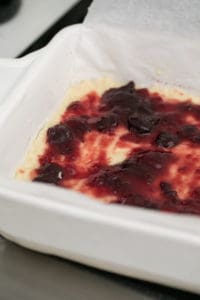 Layer of jam over shortbread crust.