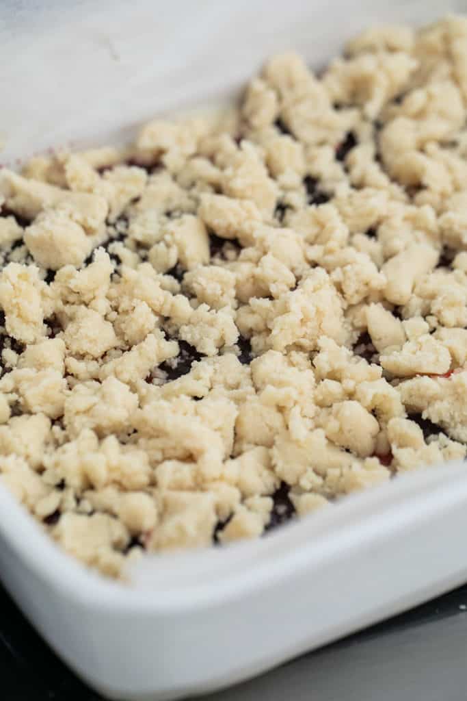 Crumbled shortbread crust over a layer of jam.