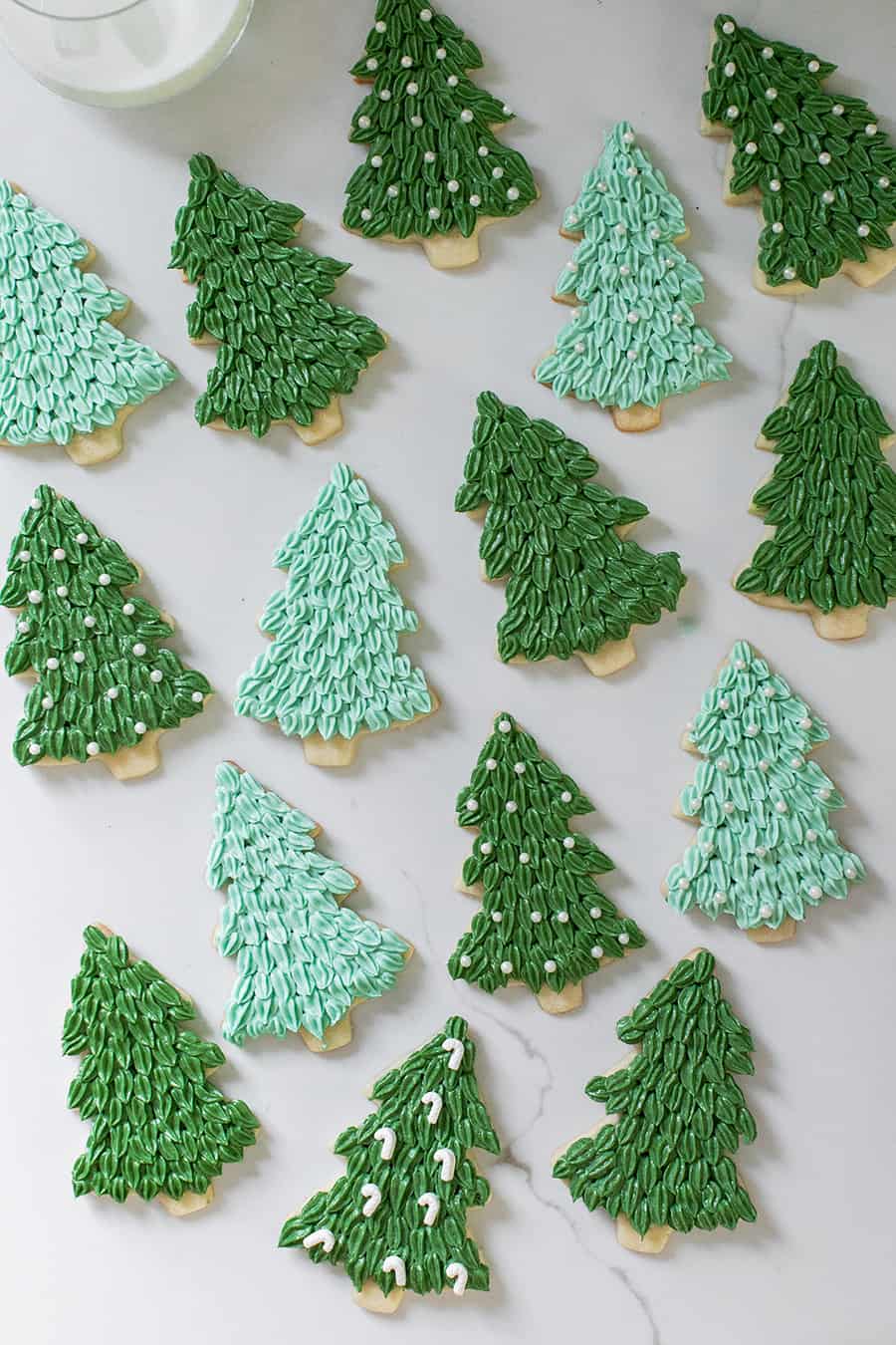 Christmas tree sugar cookies on a  marble table. 