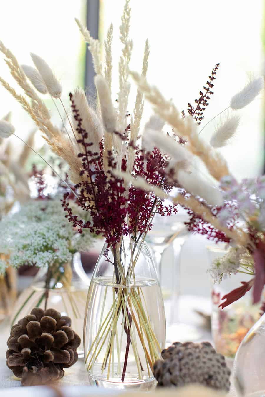 Beautiful fall flowers in a bud vase on a Thanksgiving table setting.