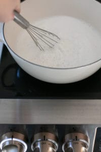 whisking hot milk on the stovetop