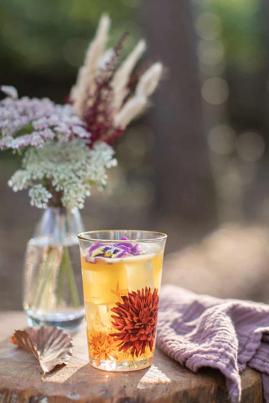 Bourbon cocktail on a flower glass on a log. 