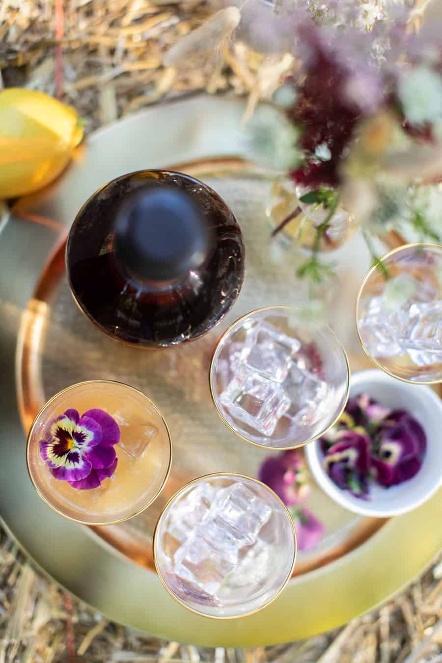 Bourbon Thanksgiving cocktail on a gold platter with an edible flower.
