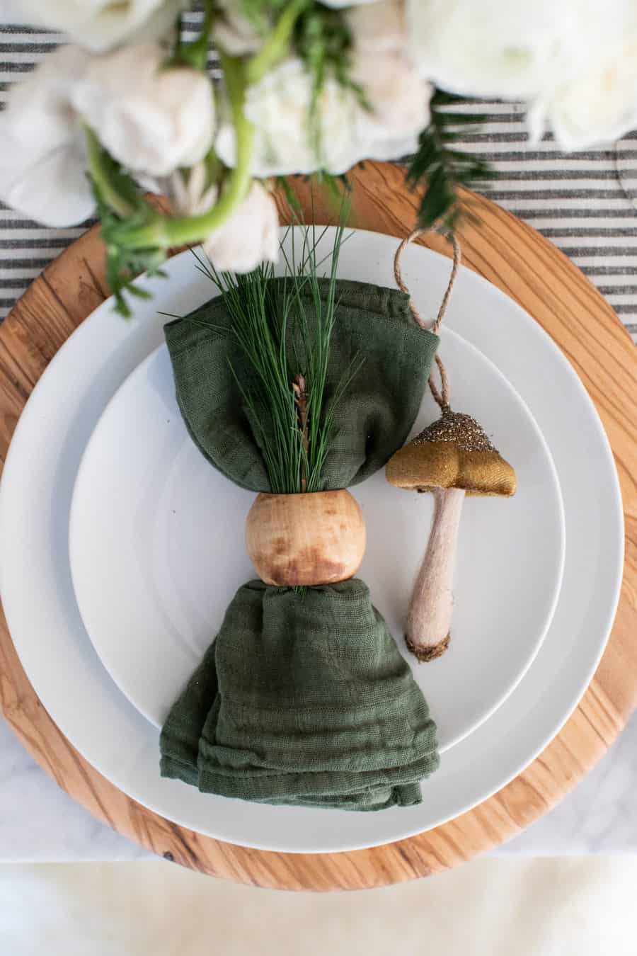 Green napkin, wooden napkin ring and a mushroom ornament.