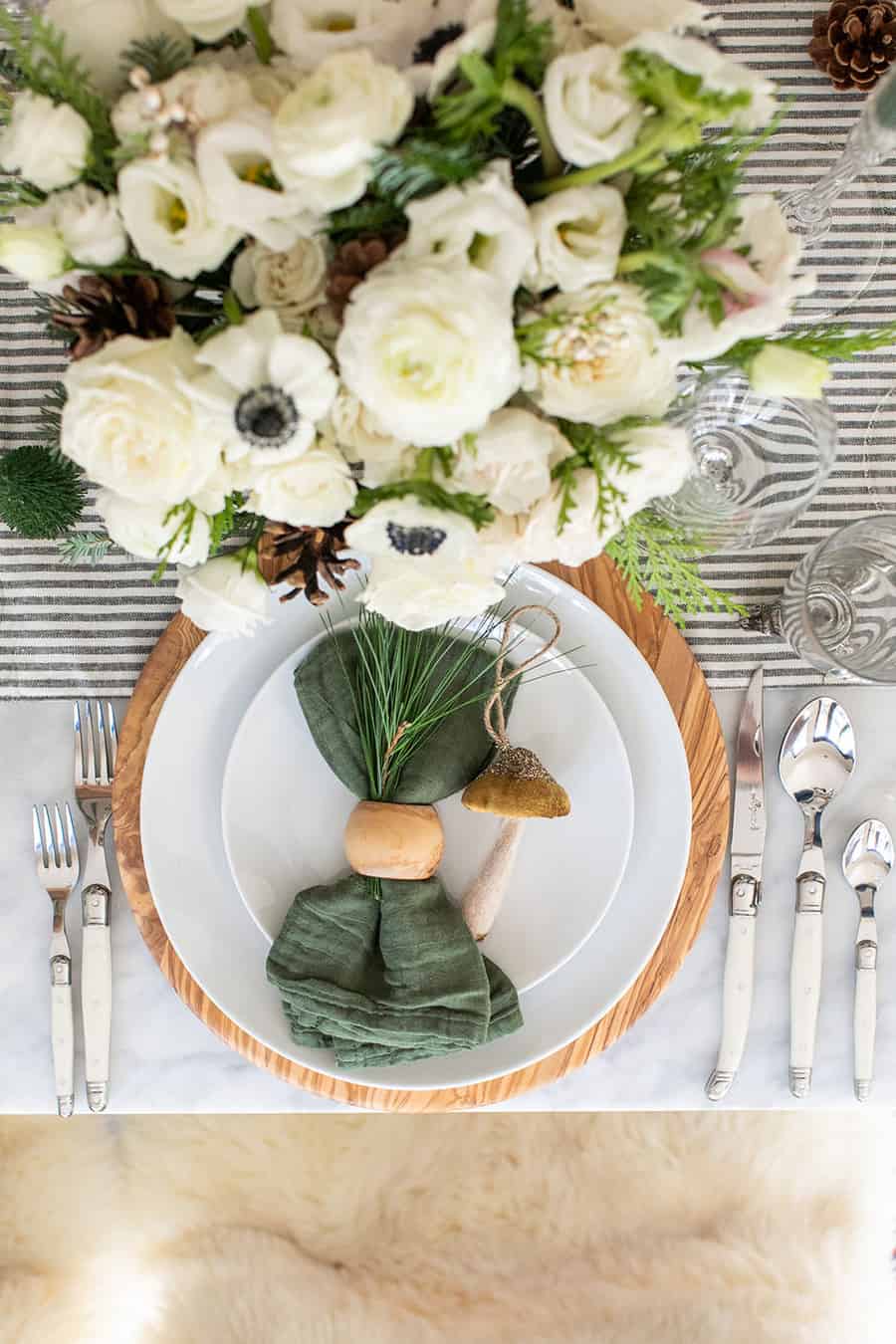 Christmas table setting, green napkin, olive wood charger, white plates from Williams Sonoma.