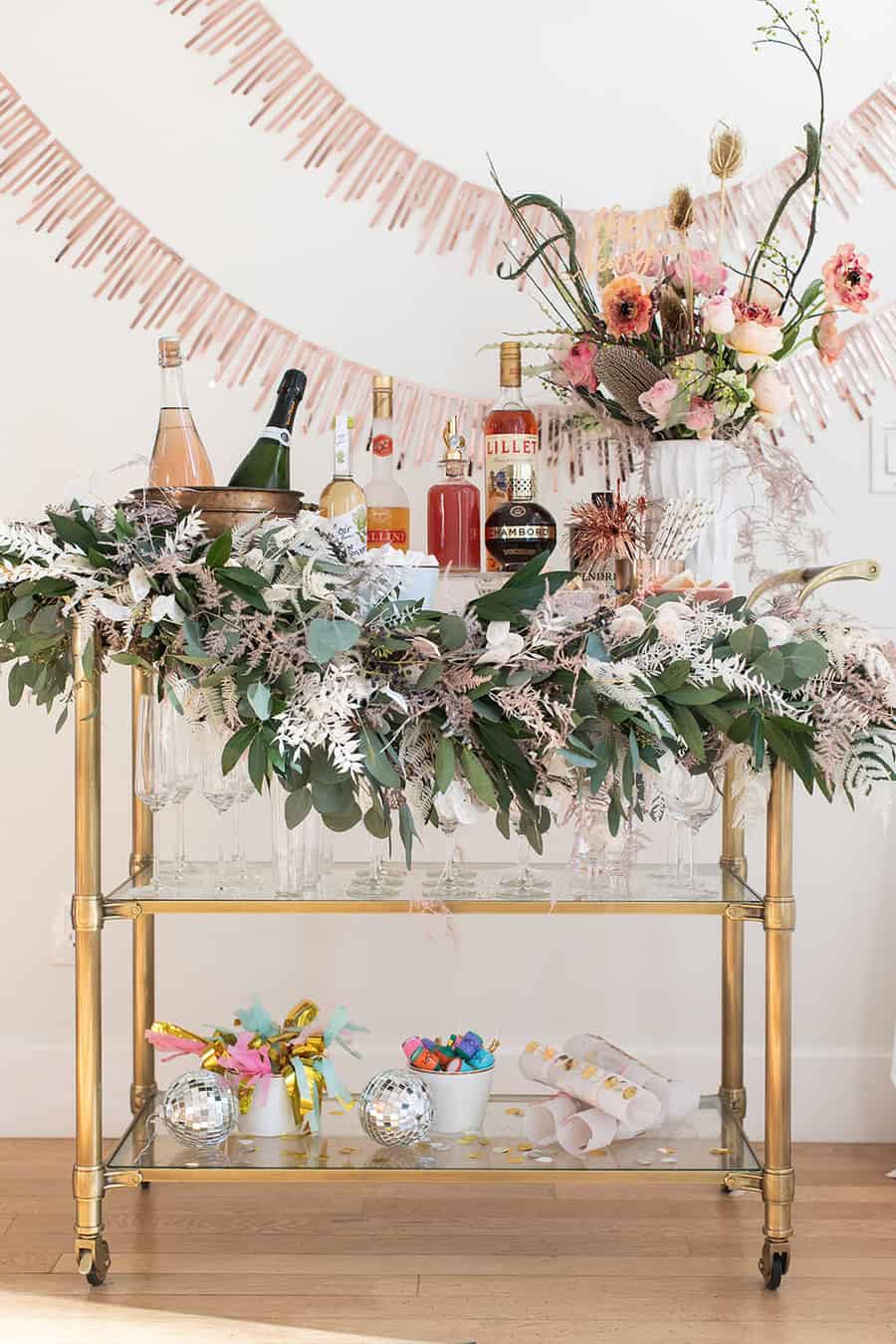 New Year's Eve Champagne Bar with garland, glasses, flowers and decorations.