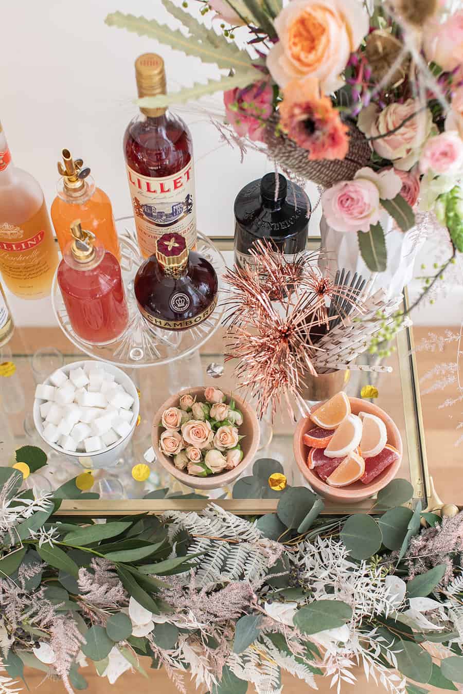 Bar with gin, toppings, sparklers and flowers for a New Year's Eve Champagne Bar