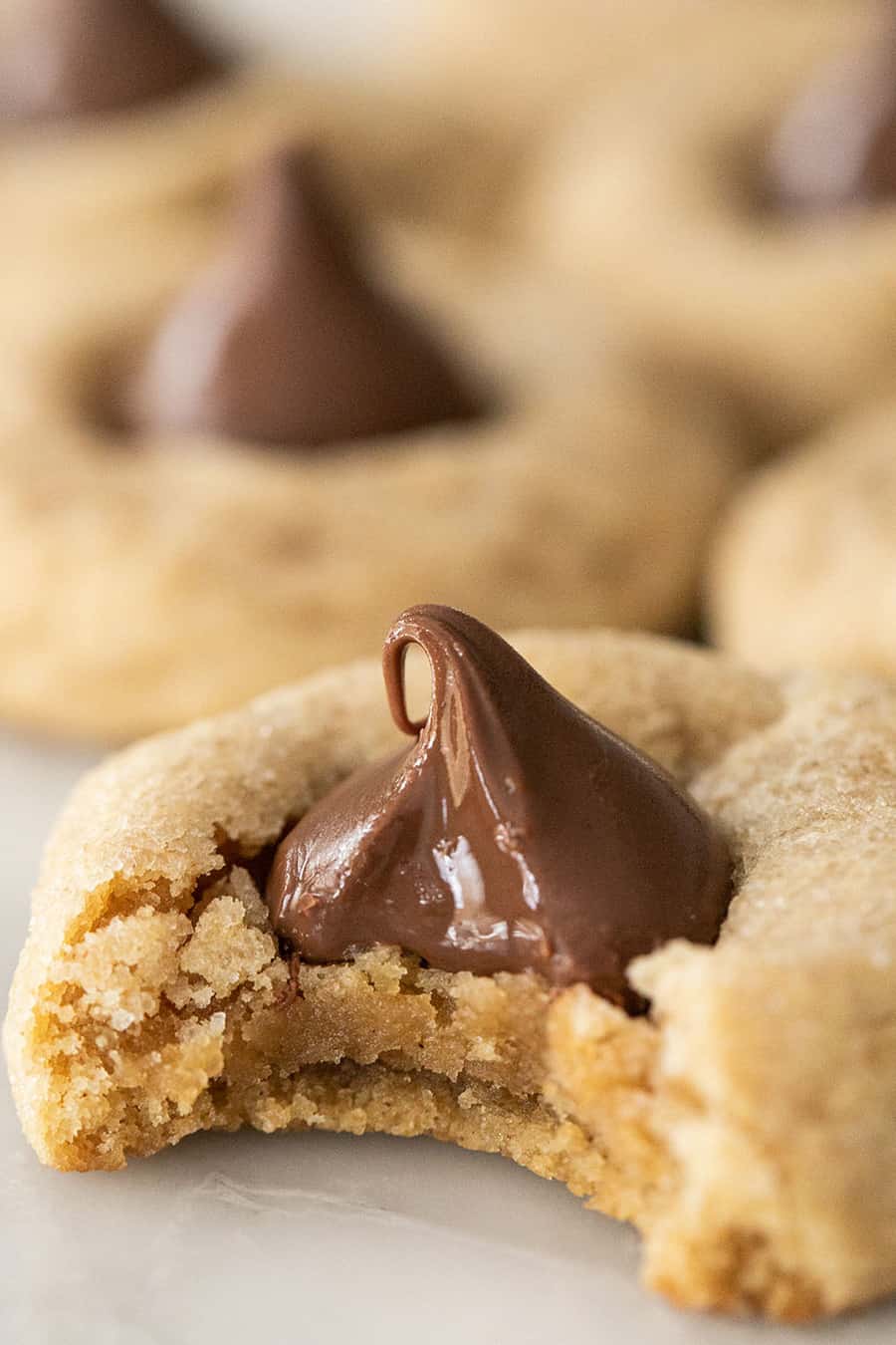 Bite taken out of chocolate peanut butter blossom cookies