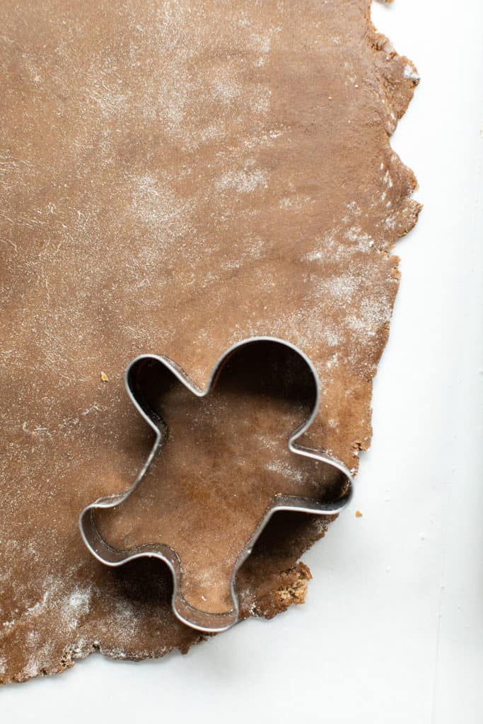 Rolling chilled gingerbread dough and cutting out gingerbread men.