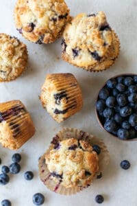 the best blueberry muffins on a table with fresh blueberries