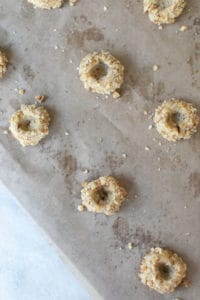 thumb print cookies on a baking sheet lined with parchment paper before baking
