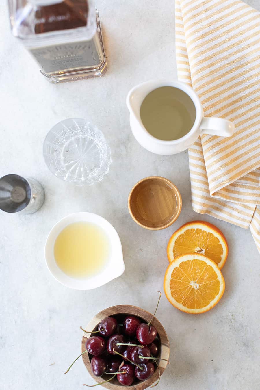 Ingredients on a marble table to make a whiskey sour recipe. 